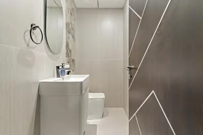 a bathroom with a toilet and a sink and a mirror at VayK - Spacious 2BR with Private Pool in Science Park in Dubai