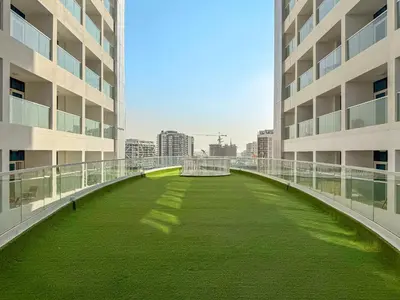 a green lawn in the middle of a building at VayK - Spacious 2BR with Private Pool in Science Park in Dubai