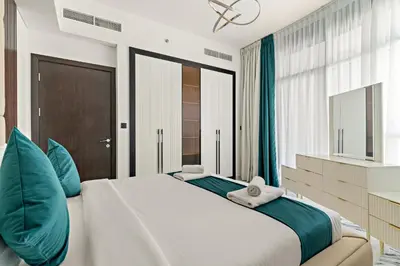 a bedroom with a large bed with blue pillows at VayK - Spacious 2BR with Private Pool in Science Park in Dubai