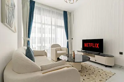 a living room with a couch and a tv at VayK - Spacious 2BR with Private Pool in Science Park in Dubai