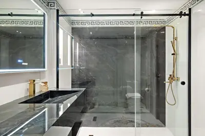 a bathroom with a shower with a glass door at VayK - Luxe 2BR with Stunning Marina Views in Dubai