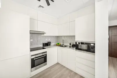 a white kitchen with white cabinets and appliances at VayK - Contemporary 2BR in Dubai Marina in Dubai