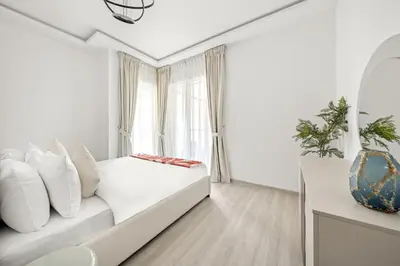 a white living room with a couch and a window at VayK - Contemporary 2BR in Dubai Marina in Dubai