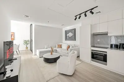 a white living room with a couch and a table at VayK - Contemporary 2BR in Dubai Marina in Dubai