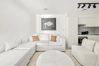 a white living room with a white couch and a table at VayK - Contemporary 2BR in Dubai Marina in Dubai