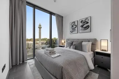 a bedroom with a large bed and a large window at Modern 1BR Apartment with Balcony in Sobha Hartland in Dubai