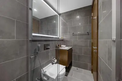 a bathroom with a toilet and a glass shower at Modern 1BR Apartment with Balcony in Sobha Hartland in Dubai