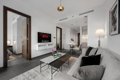 a living room with a couch and a table at Modern 1BR Apartment with Balcony in Sobha Hartland in Dubai