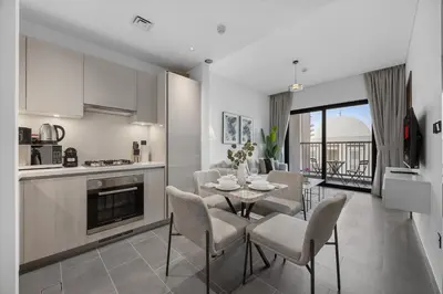 a kitchen and dining room with a table and chairs at Modern 1BR Apartment with Balcony in Sobha Hartland in Dubai