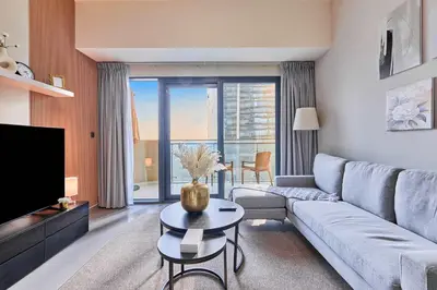 a living room with a couch and a tv at Home Away 2BR in Dubai