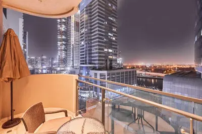 a balcony with chairs and a view of a city at Home Away 2BR in Dubai