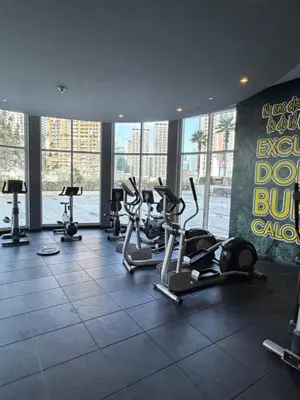 a gym with several treadmills and cardio equipment in a building at Prime location cozy apartment in Dubai