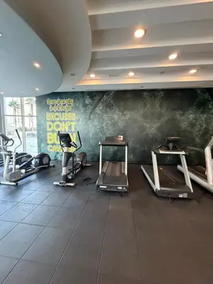 a gym with several tread machines in a room at Prime location cozy apartment in Dubai
