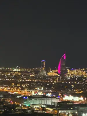 a view of a city at night with pink lights at Prime location cozy apartment in Dubai