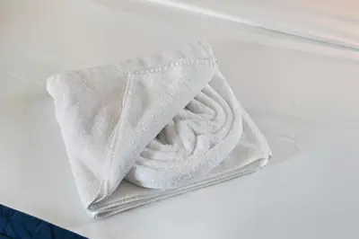 a pile of white towels sitting on a bed at Luxury 2BDR In Burj Khalifa View Business Bay in Dubai