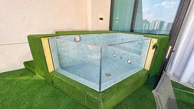 a room with a glass table in a room with green grass at AWS Holiday Homes - Stay in Style in Dubai