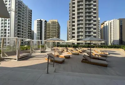a group of lounge chairs with umbrellas in a city at AWS Holiday Homes - Stay in Style in Dubai