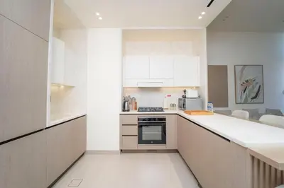 a kitchen with white cabinets and a stove top oven at AWS Holiday Homes - Stay in Style in Dubai