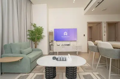 a living room with a tv and a couch and a table at AWS Holiday Homes - Stay in Style in Dubai