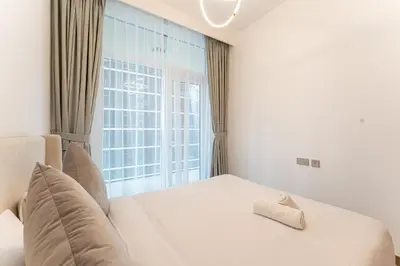 a bedroom with a white bed with a window at HAVN - 2 bedroom in Urban Oasis, Dubai Canal View in Dubai