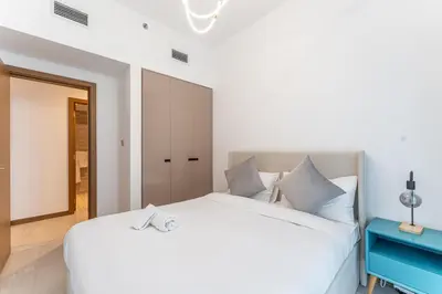 a bedroom with a white bed and a mirror at HAVN - 2 bedroom in Urban Oasis, Dubai Canal View in Dubai