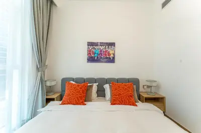 a bedroom with a bed with orange pillows at HAVN - 2 bedroom in Urban Oasis, Dubai Canal View in Dubai
