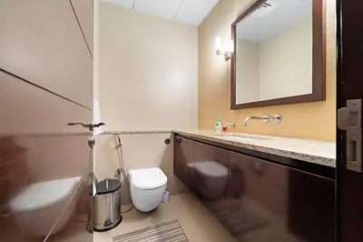 a bathroom with a toilet and a sink and a mirror at VayK - Spacious 2BR with Private Gym & Beach Access in Dubai