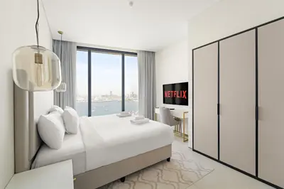 a hotel room with a bed and a large window at VayK - Luxurious 2BR Beachfront Retreat with Ocean View in Dubai
