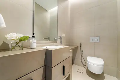 a bathroom with a toilet and a sink and a mirror at VayK - Luxurious 2BR Beachfront Retreat with Ocean View in Dubai