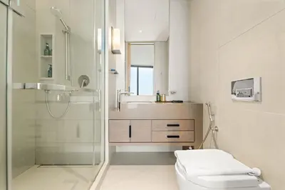 a bathroom with a shower and a toilet and a sink at VayK - Luxurious 2BR Beachfront Retreat with Ocean View in Dubai