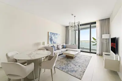 a white living room with a table and chairs at VayK - Luxurious 2BR Beachfront Retreat with Ocean View in Dubai