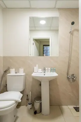 a bathroom with a toilet and a sink and a mirror at Luxury Beachfront 4BR with Sea & Marina Views in Dubai