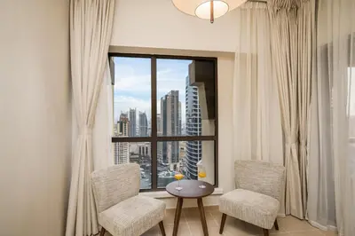 a room with two chairs and a table and a large window at Luxury Beachfront 4BR with Sea & Marina Views in Dubai