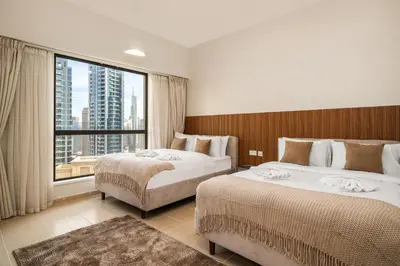 a hotel room with two beds and a large window at Luxury Beachfront 4BR with Sea & Marina Views in Dubai