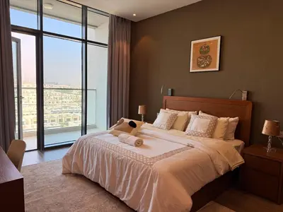 a bedroom with a large bed with a large window at Spacious 1BR- Sepcoo III Residence Al Furjan-1009 in Dubai