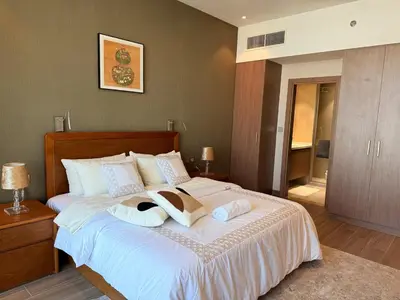 a bedroom with a large bed with towels on it at Spacious 1BR- Sepcoo III Residence Al Furjan-1009 in Dubai