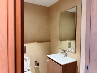 a bathroom with a sink and a mirror and a toilet at Spacious 1BR- Sepcoo III Residence Al Furjan-1009 in Dubai
