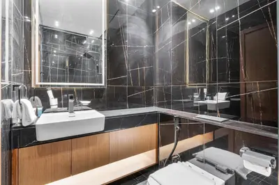a black tiled bathroom with a sink and a toilet at ALiving Cozy Studio I Binghatti Galaxy, JVC- G02 in Dubai