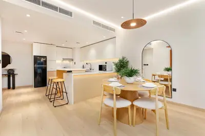 a kitchen and dining room with a table and chairs at Vacay Lettings - Elite Residence - 1 BR - Partial Sea View in Dubai