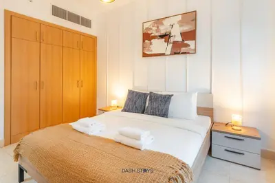 a bedroom with a large bed with towels on it at Lux 2BR in Dubai Marina Walk to Beach & Metro in Dubai