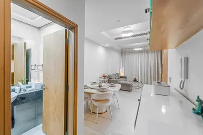 a dining room and living room with a table in a room at Escape24 Elegant 1BR with City View near Dubai Mall in Dubai