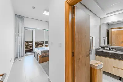 a bathroom with a sink and a bedroom with a bed at Escape24 Elegant 1BR with City View near Dubai Mall in Dubai
