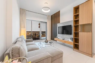 a living room with a couch and a tv at Escape24 Elegant 1BR with City View near Dubai Mall in Dubai