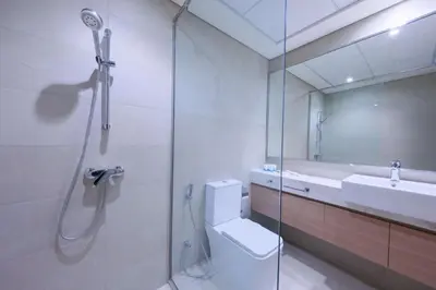 a bathroom with a shower and a toilet and a sink at Spacious 2BHK at Azizi Riviera 22 Meydan in Dubai
