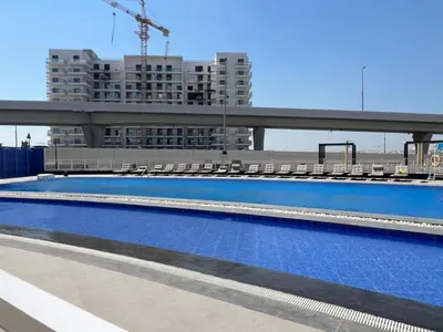 a large swimming pool on the roof of a building at Blissful Retreat 1BR with 1GR Study Sleeps 4 in Gemz 05 in Dubai