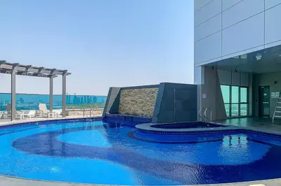 a large blue swimming pool in front of a building at Frank Porter - The Bay in Dubai