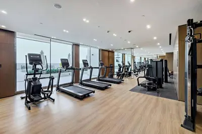 a gym with treadmills and ellipticals in a building at Stylish 1BR Studio Unit Balcony & Pool in Dubai