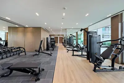 a gym with a row of treadms and cardio machines at Stylish 1BR Studio Unit Balcony & Pool in Dubai