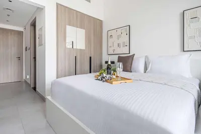 a bedroom with a large white bed with a tray on it at Frank Porter - Oxford Boulevard in Dubai