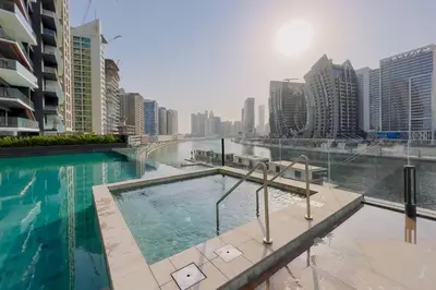 a swimming pool in a city with tall buildings at GuestReady - 1BR l Burj Khalifa & Canal Views in Dubai